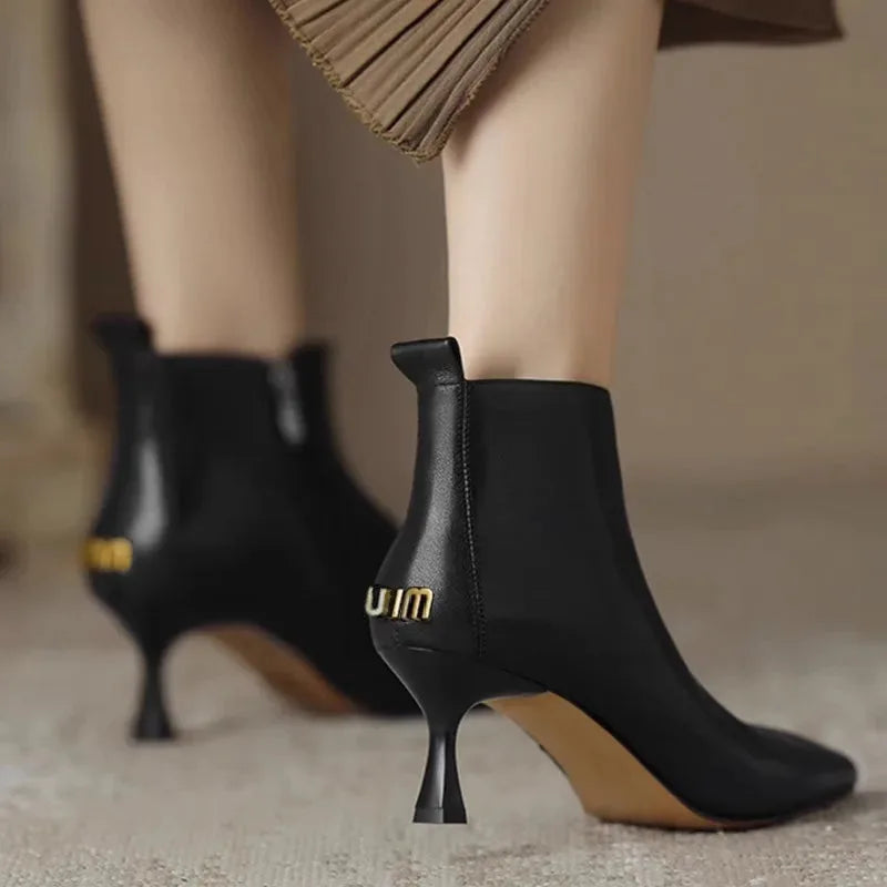 Women's faux leather side zip ankle boots with 'uim' lettering